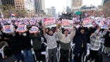 Yoon Suk Yeol supporters at a rally holding up signs