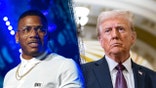 Nelly in a white polo shirt and chain necklace with transparent eyeglasses looks tohis left on stage split Donald Trump in a navy jacket and purple tie looks to his right