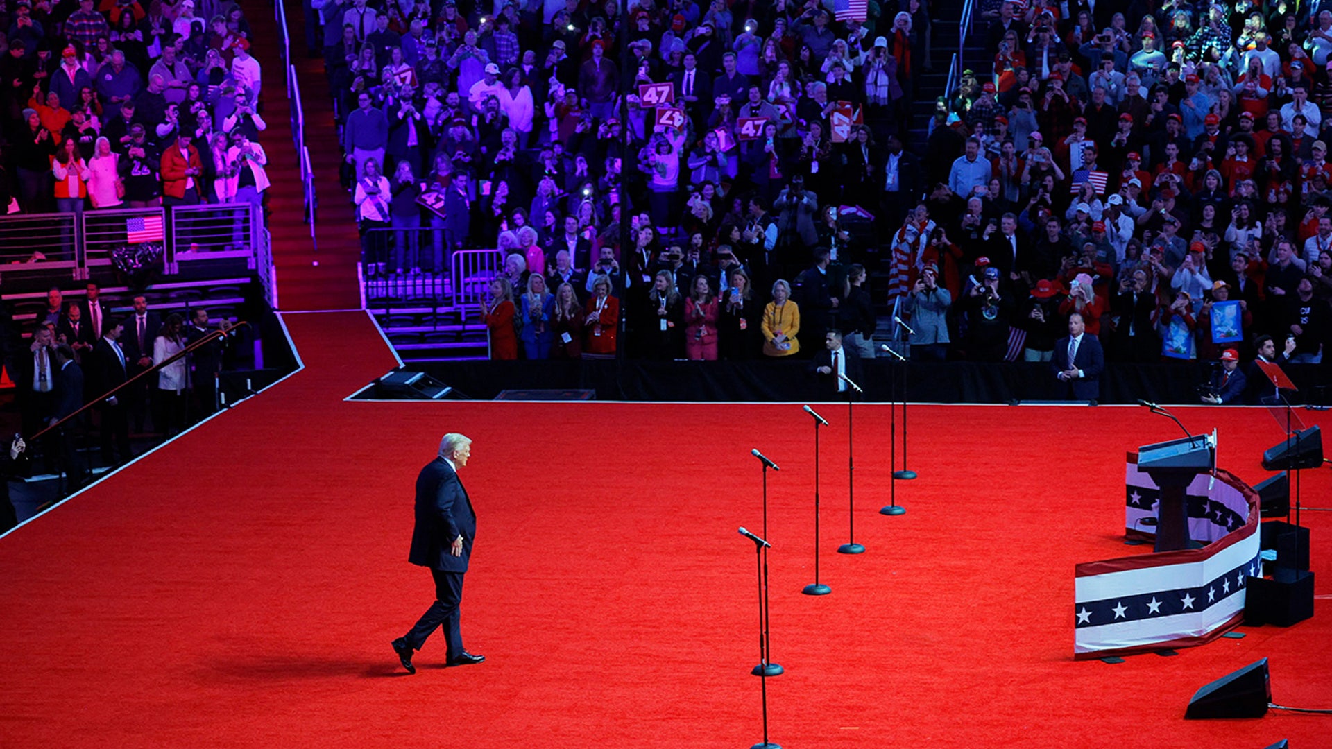 Donald Trump greets supporters from the stage during a rally the day before he is scheduled to be inaugurated for a second term