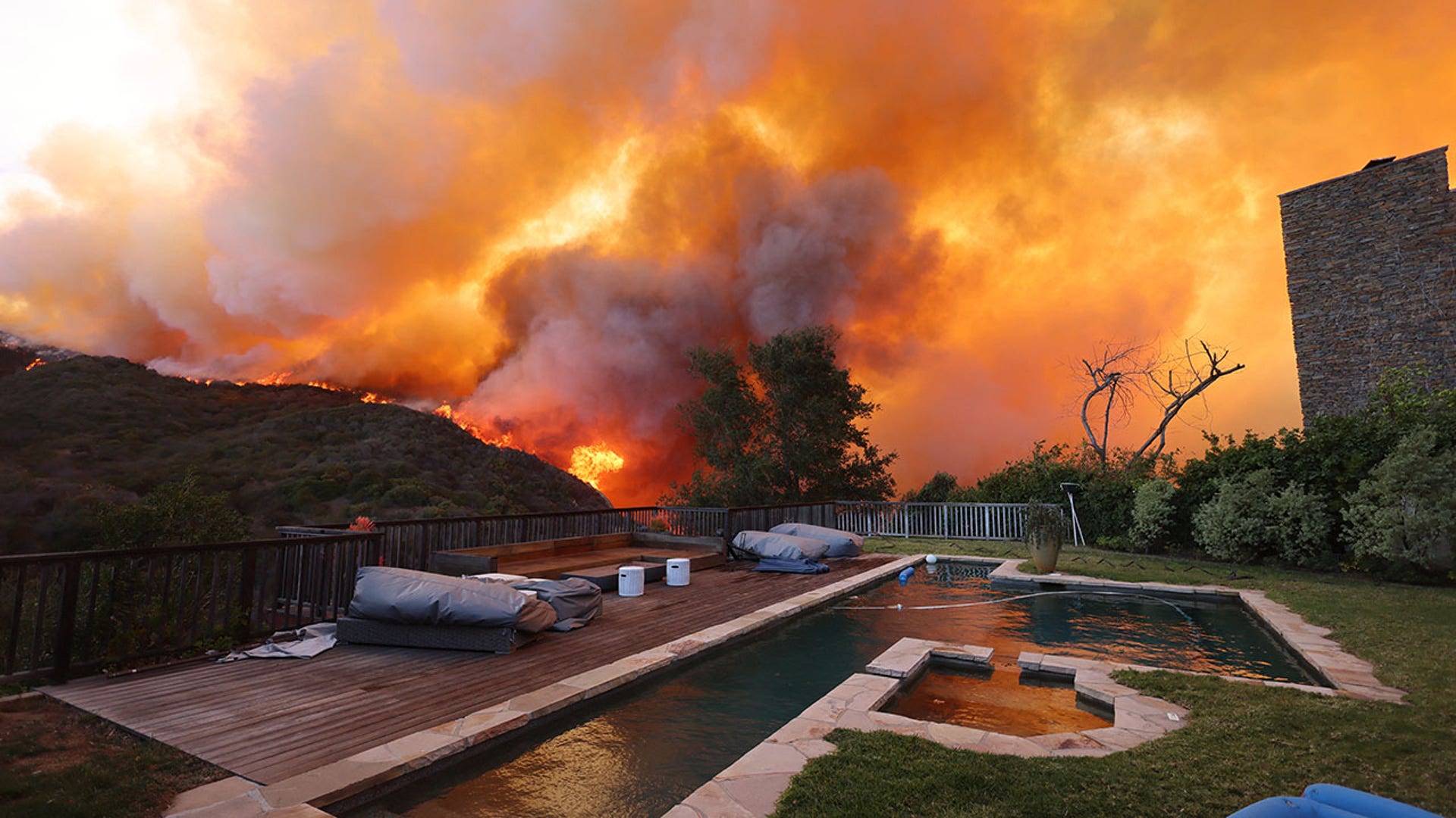 Pool seen with blazing Palisades fire approaching
