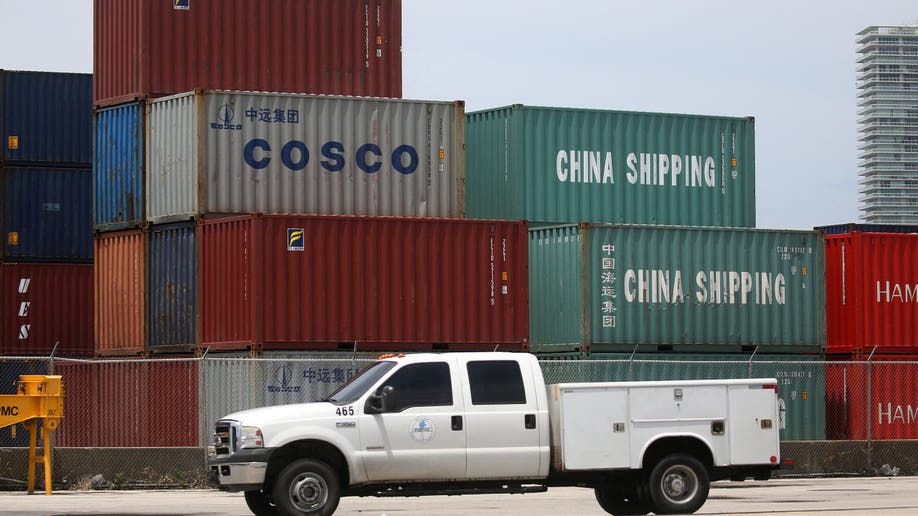 A truck driving past shipping containers