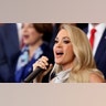 Carrie Underwood sings into the phone while looking out into the auidence