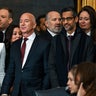 Mark Zuckerberg in a dark suit and red tie stands next to Lauren Sánchez in a white jacket next to Jeff Bezos in a dark suit