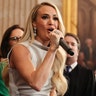 Carrie Underwood in a silver/grey dress performs "America The Beautiful" at the inauguration of President Trump