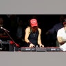 Kid Rock in a black tank top and a red 'Make America Great Again' hat plays with the music board on stage at the MAGA Victory Rally