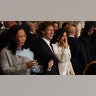 Mark Zuckerberg laughs alongside Lauren Sánchez, wearing a cream jacket covering her mouth