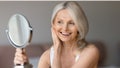 Aged natural beauty concept. Happy senior woman looking at mirror, touching her face and smiling to reflection, enjoying new skincare treatment products - Fox News