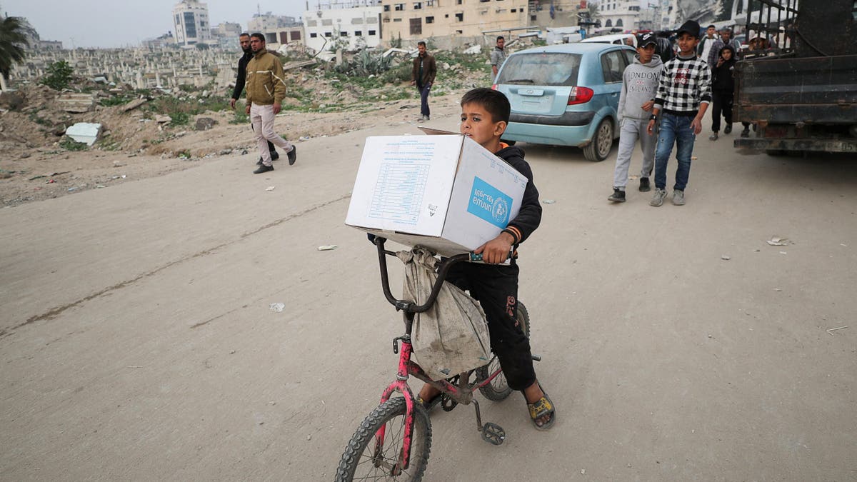A Palestinian boy carries an aid box provided by UNRWA, amid a ceasefire between Hamas and Israel, in Gaza City, on Feb. 3, 2025.