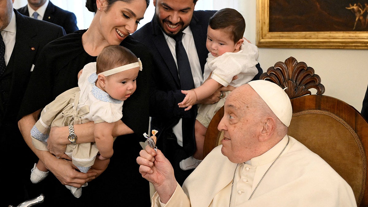 Pope Francis with a baby providing a blessing