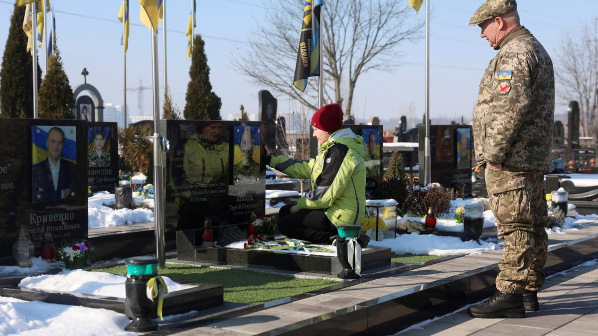 A woman and a man visit a memorial commemorating the anniversary of the war in Ukraine
