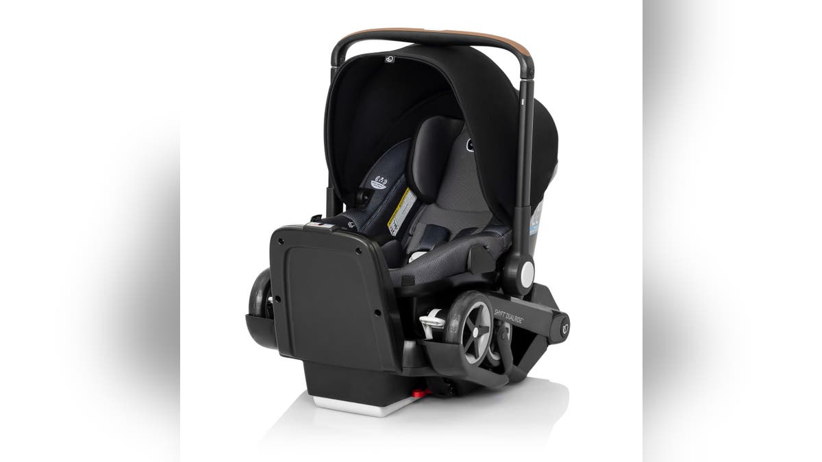 A car seat with fold-out wheels. 