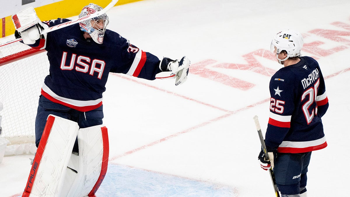 Connor Hellebuyck and Charlie McAvoy celebrate