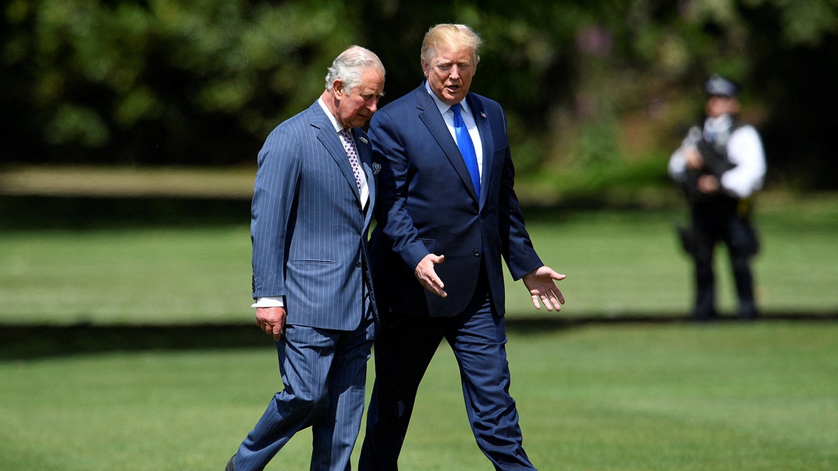 King Charles and President Trump walking side by side wearing blue suits