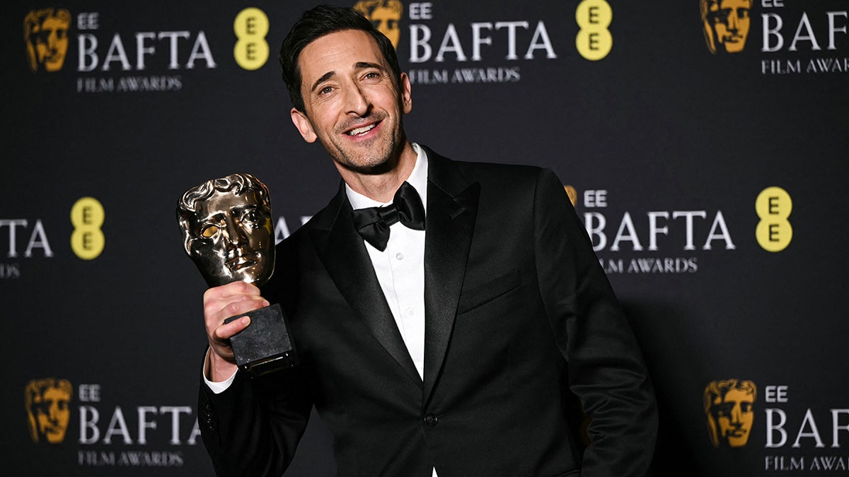 Adrien Brody posing with his BAFTA Award at the BAFTAs