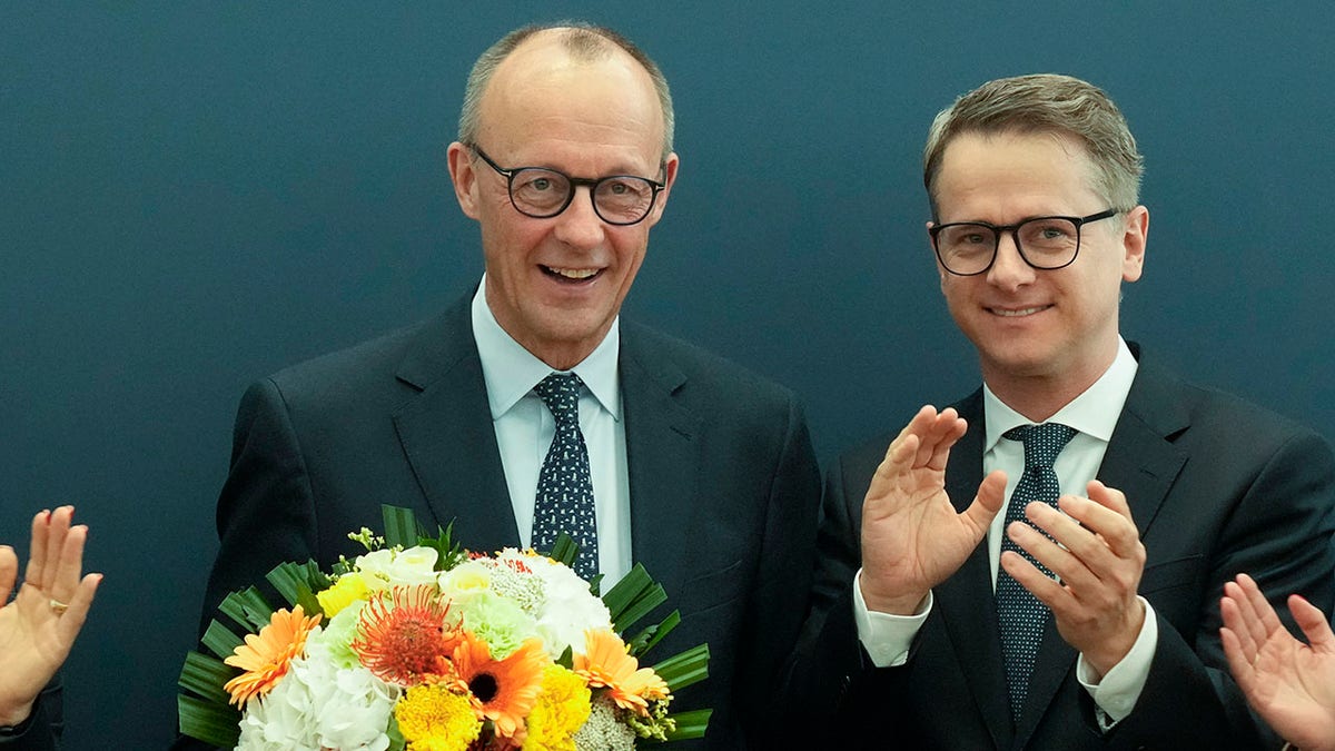 Merz holding flowers at party headquarters after election win