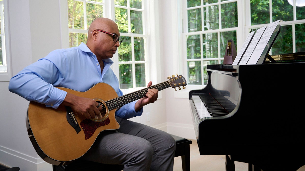 Bernie Williams touches the guitar