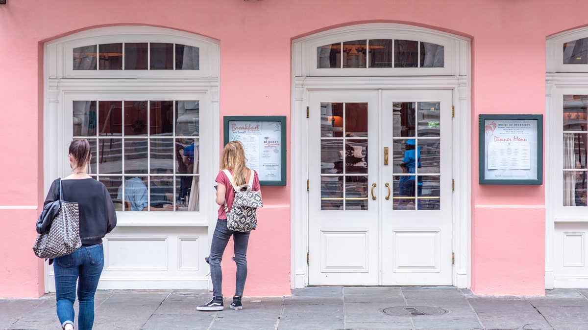 A woman looks at the menu displayed outside Brennan's in New Orleans in 2019.