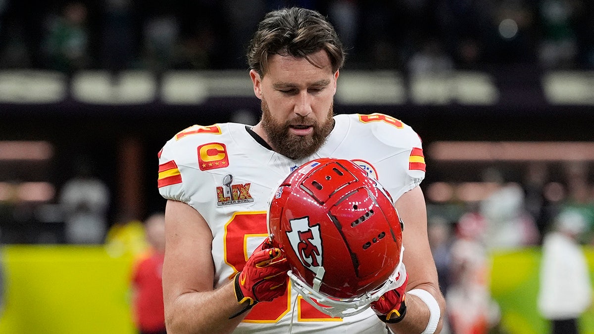 Travis Kelce menyesuaikan helmnya