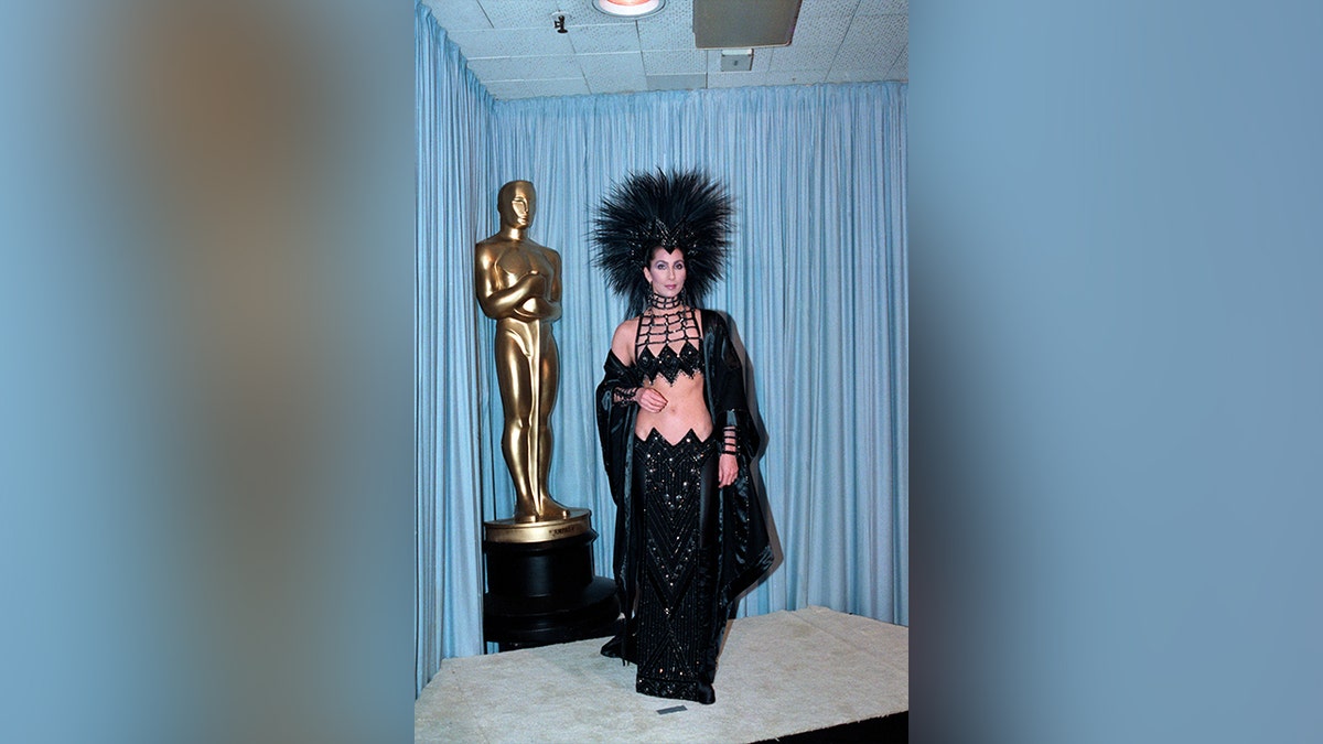 Cher wore a black two-piece dress to the 1986 Oscars, which featured a large headpiece.