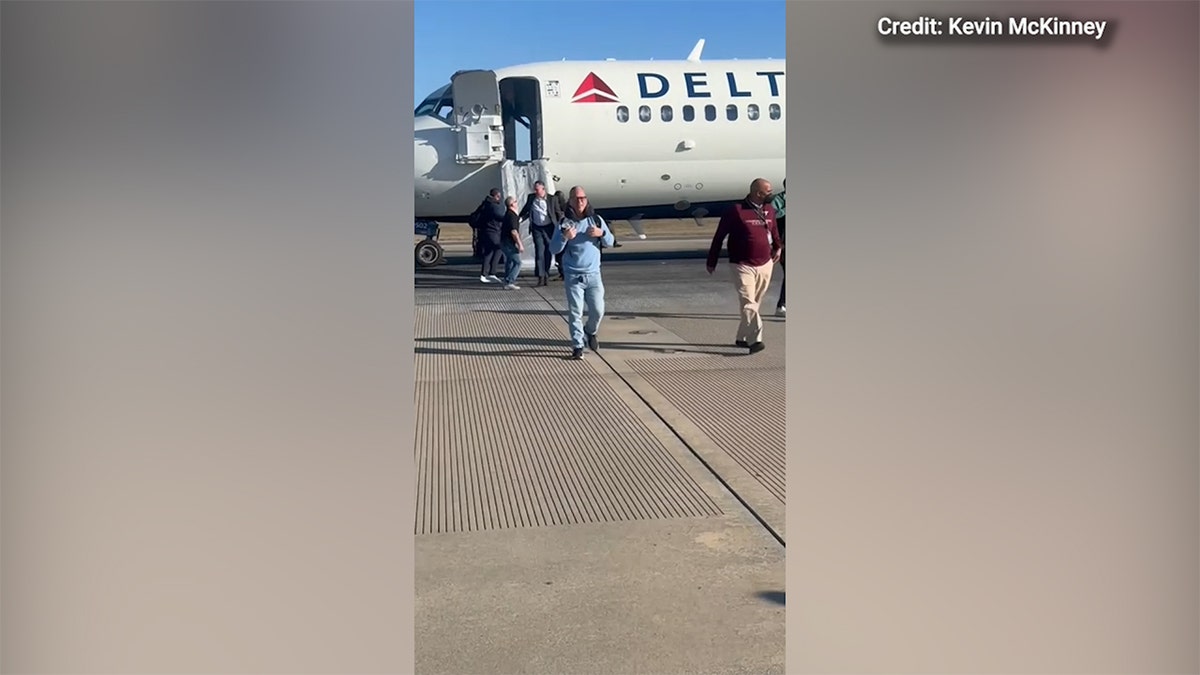 Delta passengers exit onto runway