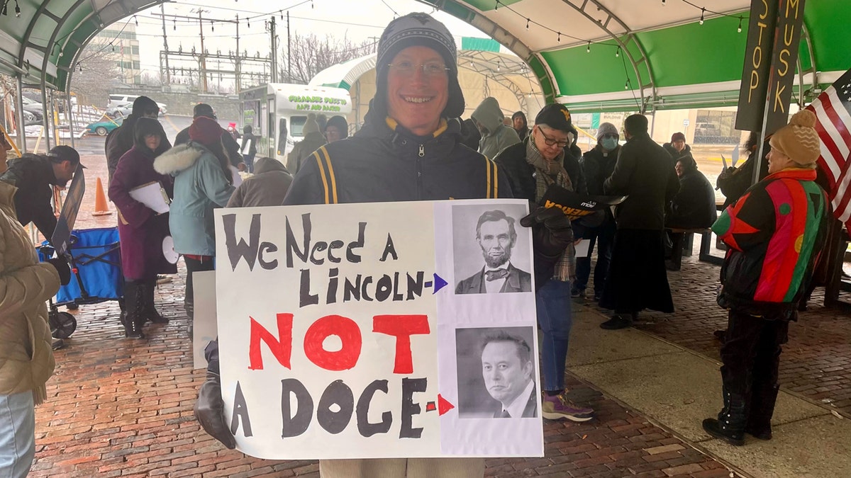 A DOGE protester holds a sign in Parkersburg, West Virginia on Tuesday.