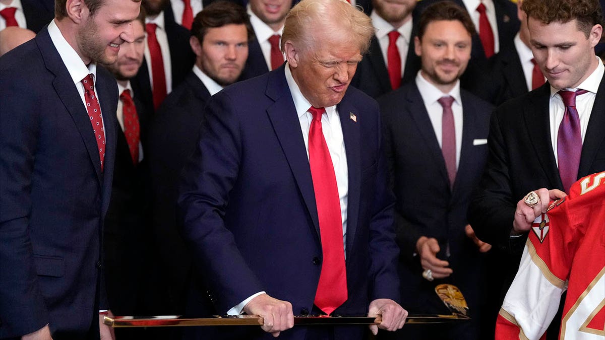 Trump holds the golden song hockey stick