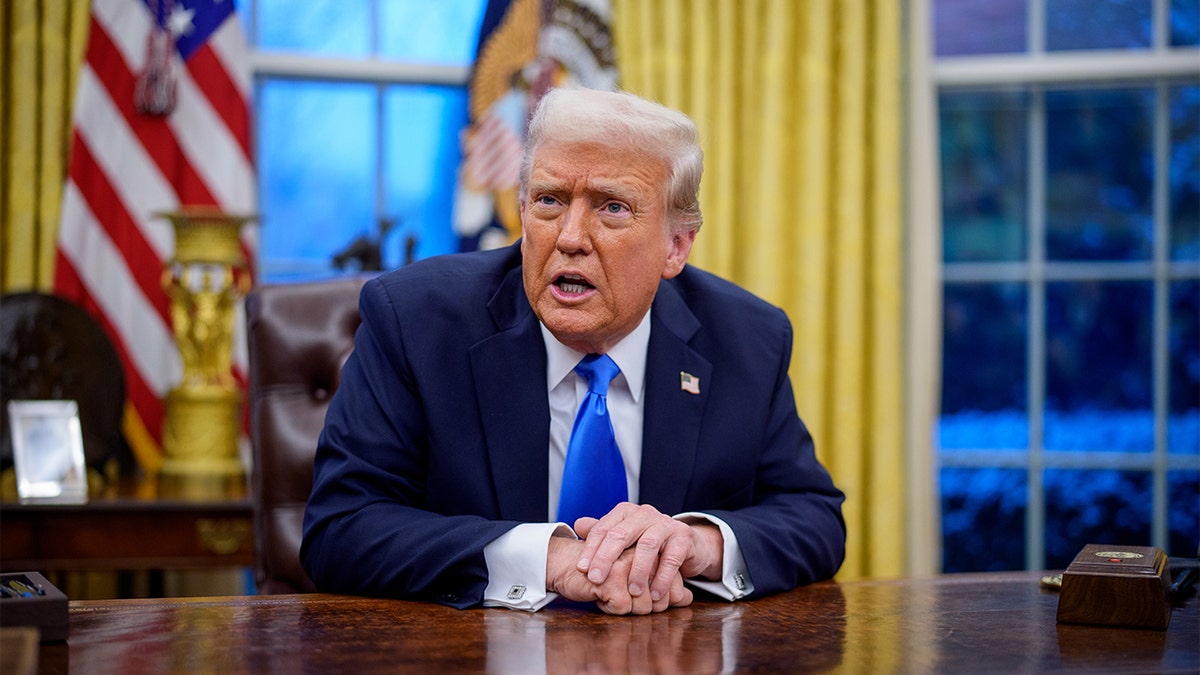 President Donald Trump sits in an iron office in the Oval Office