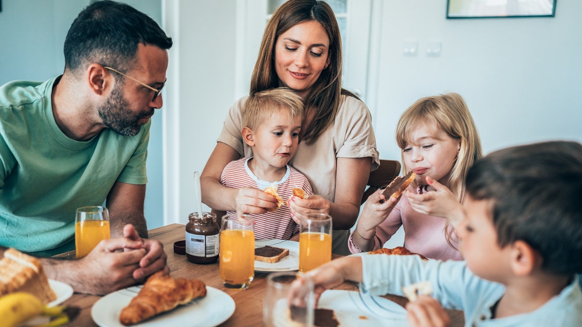 A cheerful family is having breakfast together at home.