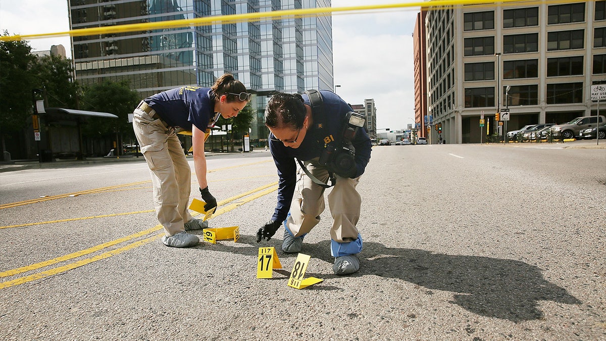 Members of a FBI evidence response team seek in an area