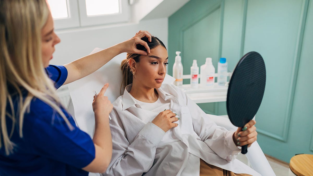 plastic surgeon reviewing procedure on female client