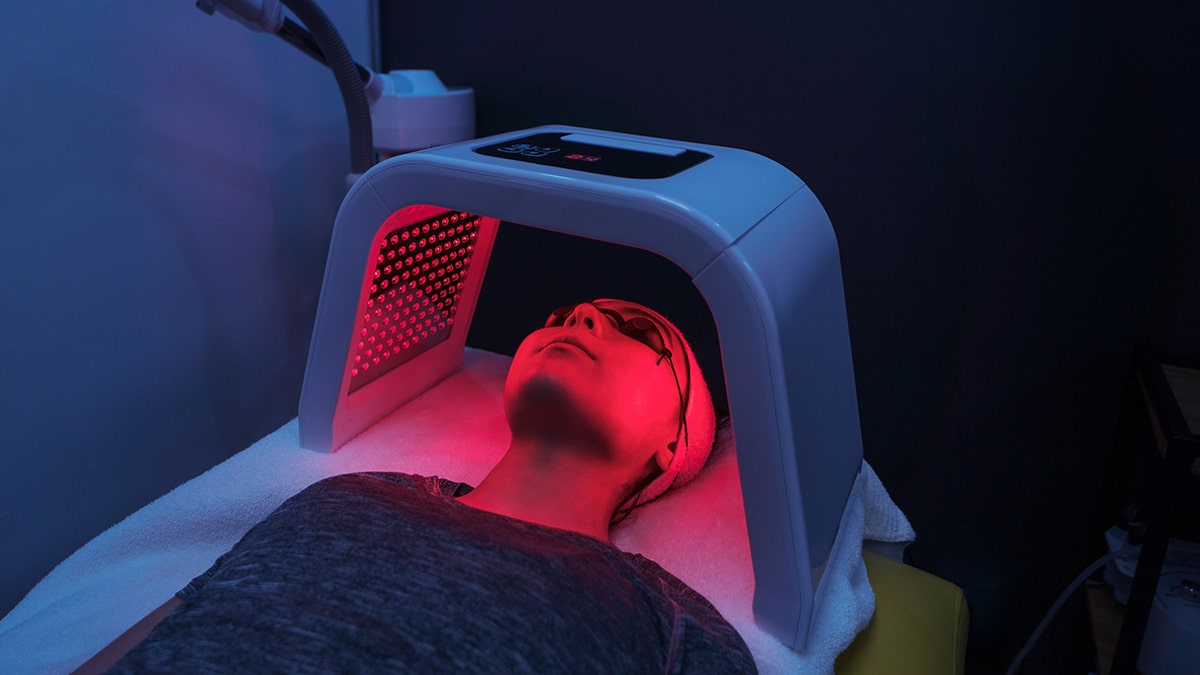 Woman who puts red light therapy over the head.