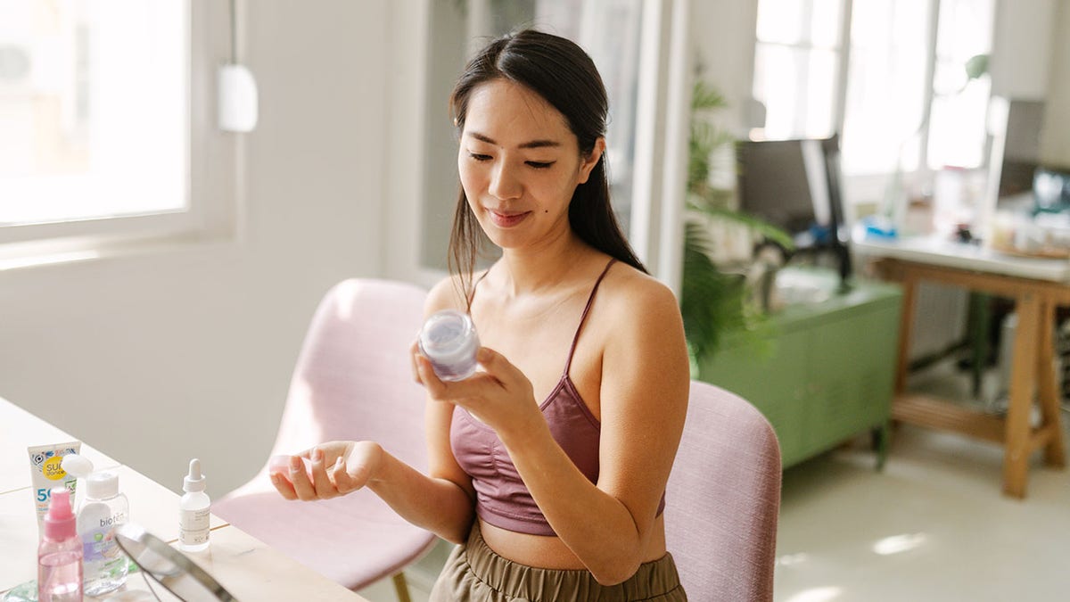 woman reading the ingredients on a skincare product