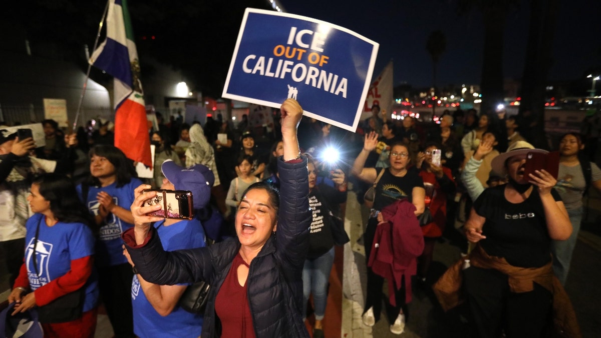 Sanctuary city supporters hold up signs in protest