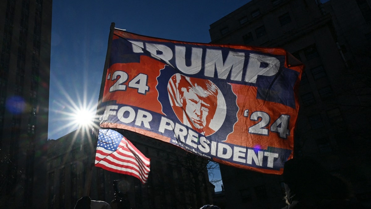 Supporters of US President-elect Donald Trump wave flags during his sentencing over cover-up of hush-money paid to adult film actress Stormy Daniels at the Manhattan Criminal Court in New York on January 10, 2025.