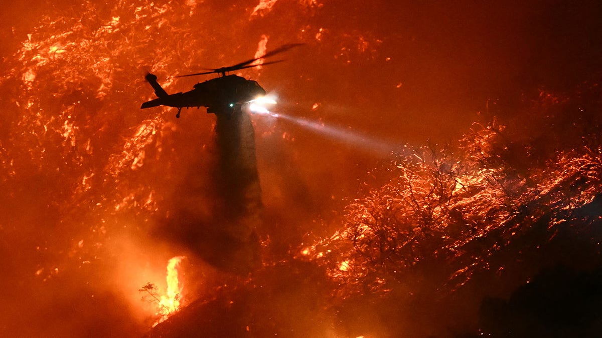 Api palisades dengan helikopter di langit 