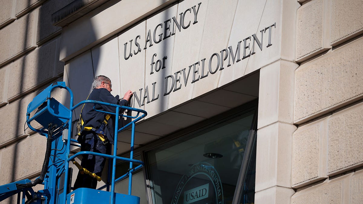 USAID sign being taken down