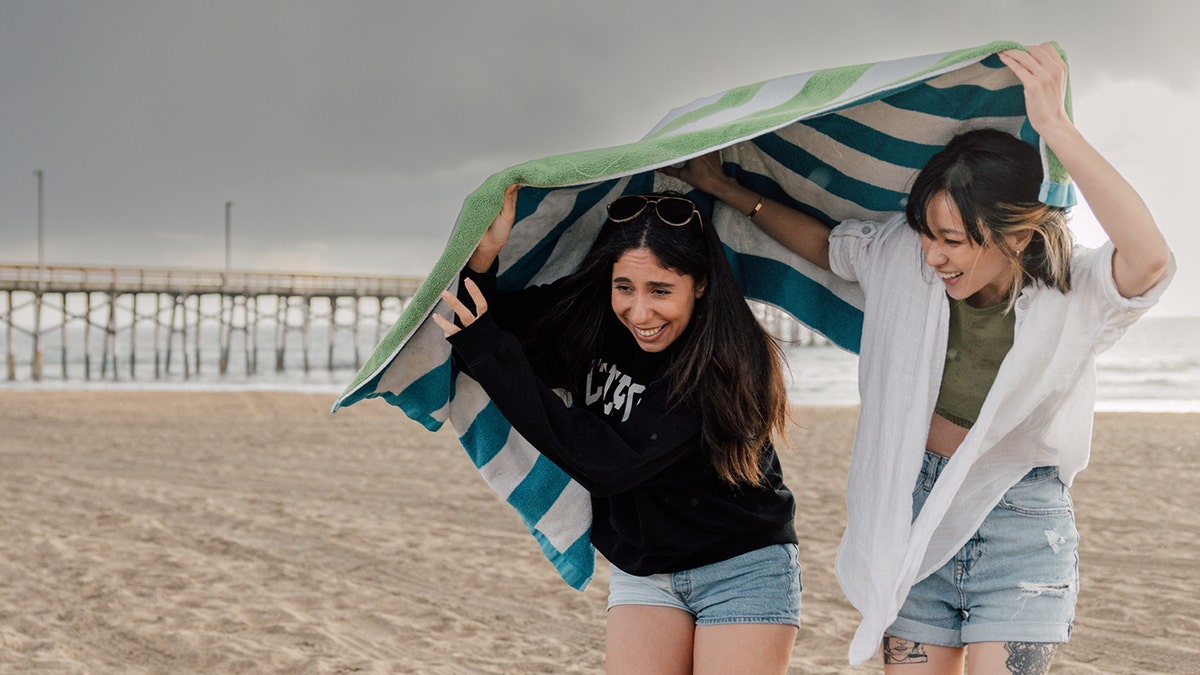 girls caught in rain on beach