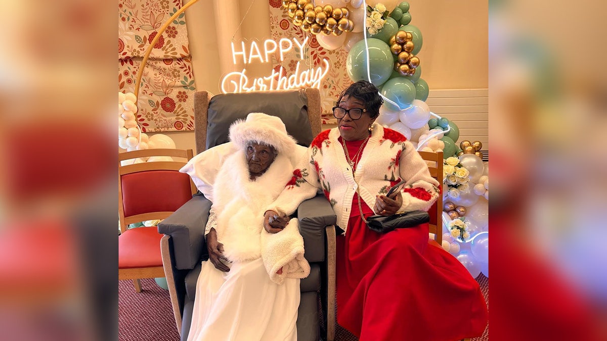 Great-great-great grandmother Mary Thomas at her birthday party, sitting next to family member.