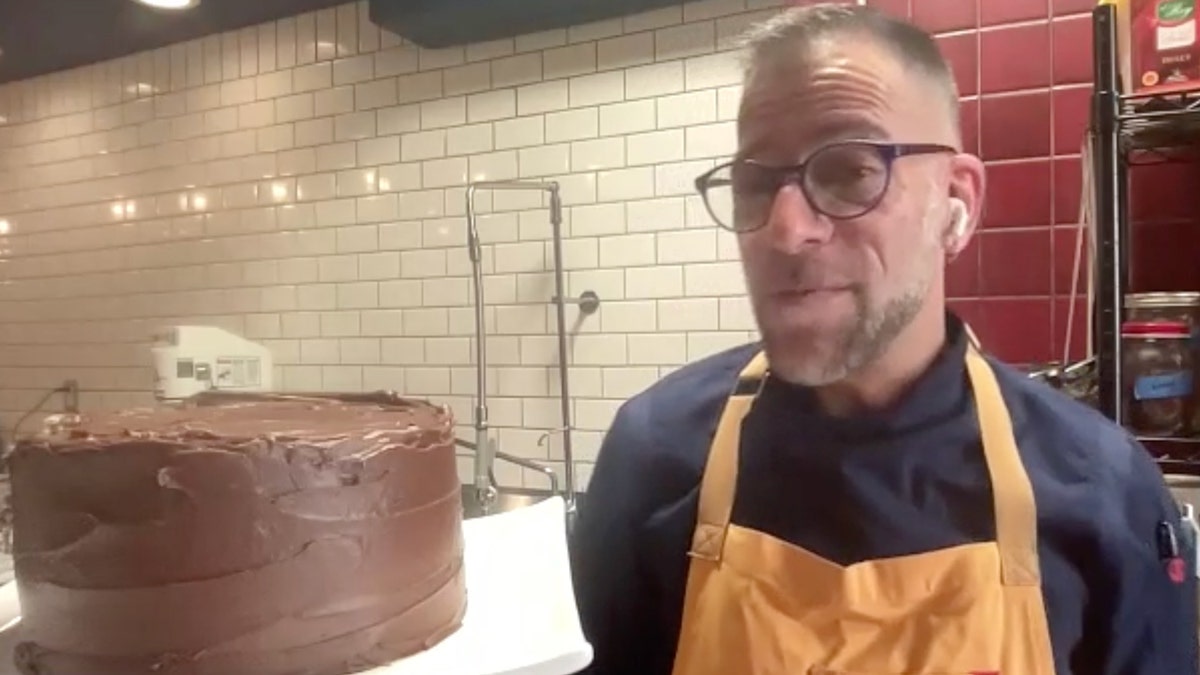 James Bird Gregory Lyon stands next to the devil cake he made.