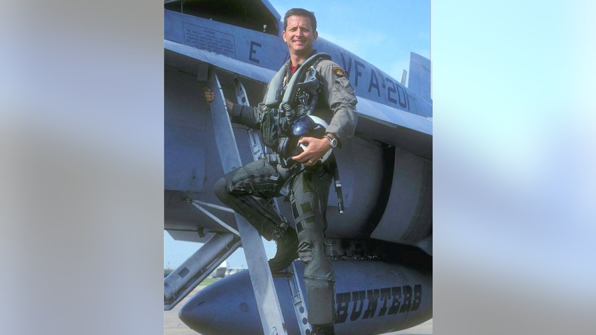 Navy fighter pilot Matthew Buckley pictured with his fighter jet