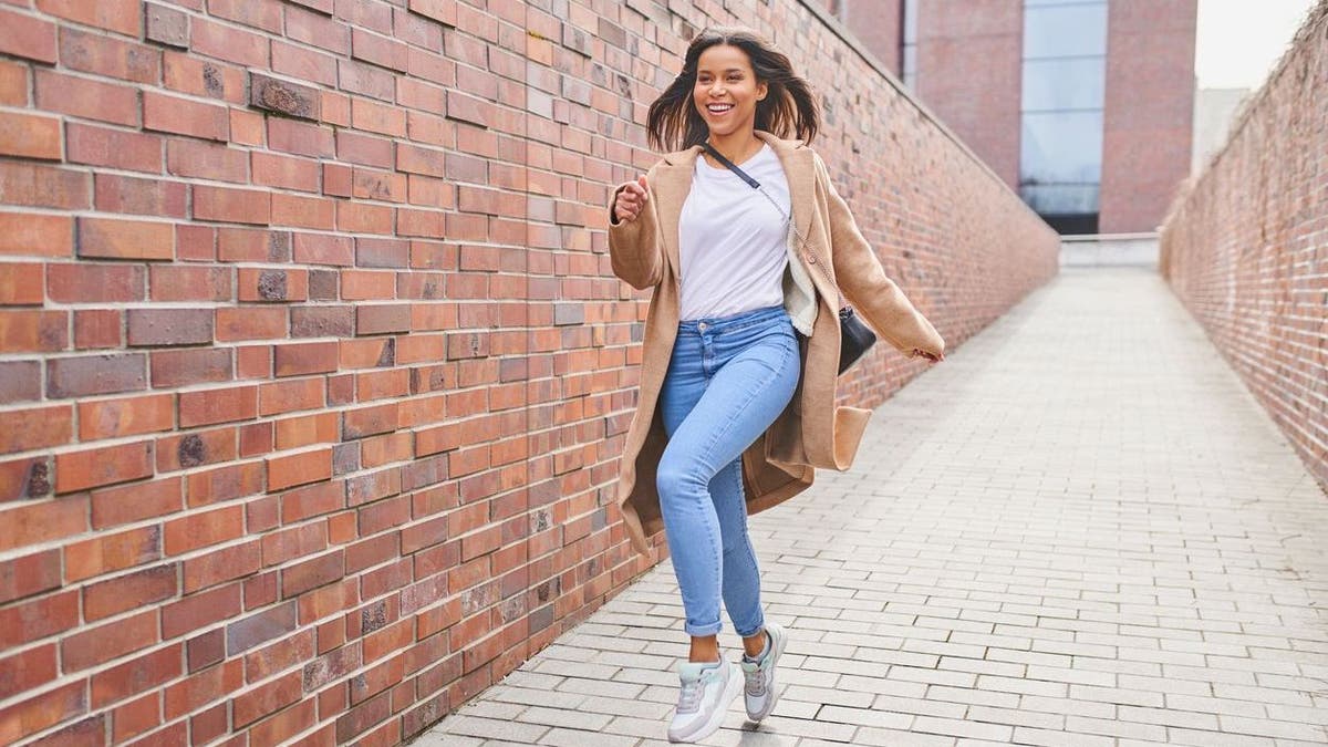 Happy woman jumping on the pavement in the city