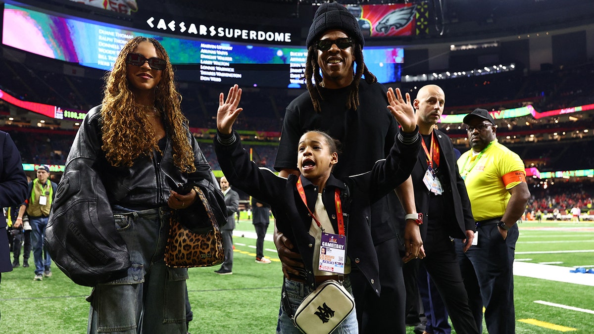 Jay-Z, Blue Ivy and Rumi on the field at the Super Bowl.