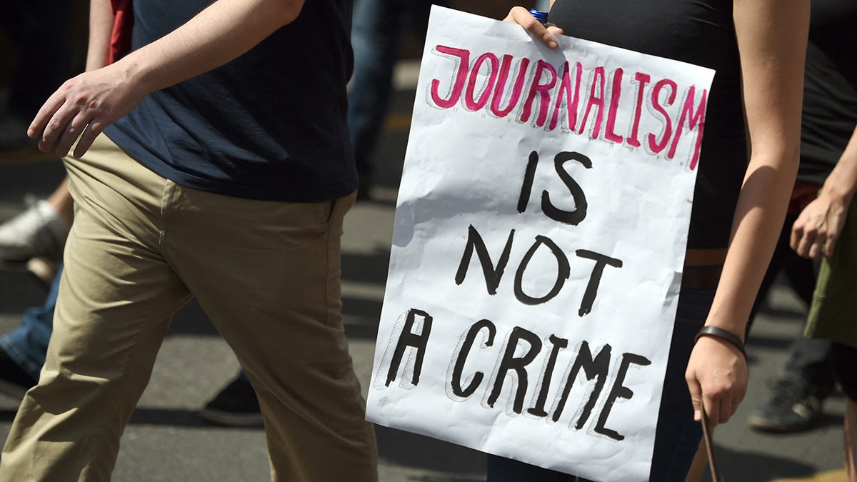 A sign reading "Journalism is not a crime."