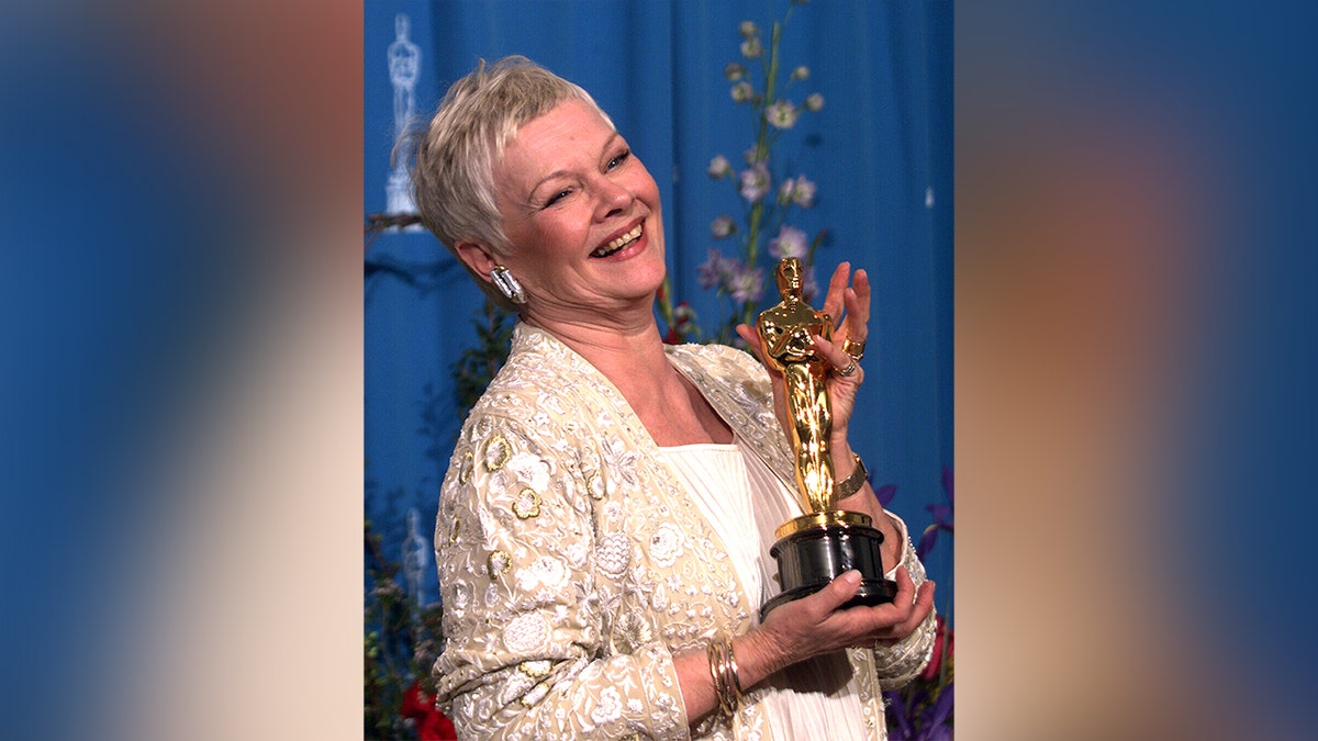 Judi Dench holding her Oscar at the 1999 Academy Awards.