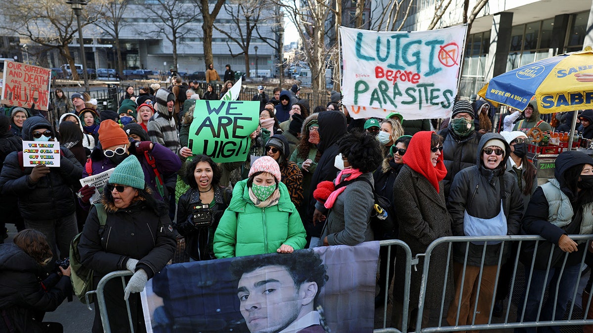 Supporters of Luigi Mangione stand outside of a NYC court