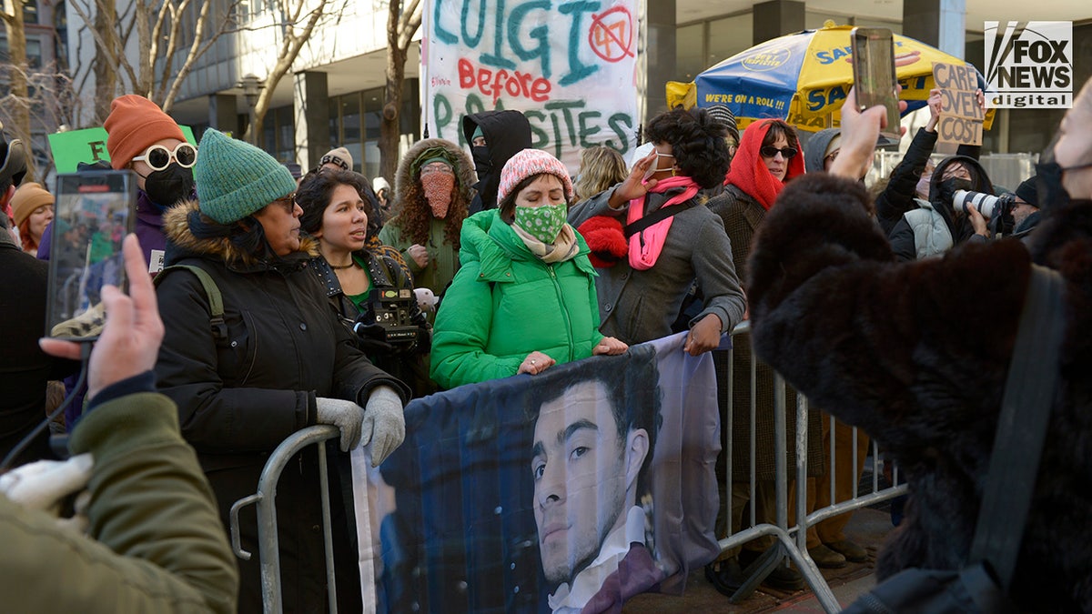 Supporters of Luigi Mangione stand outside of a NYC court