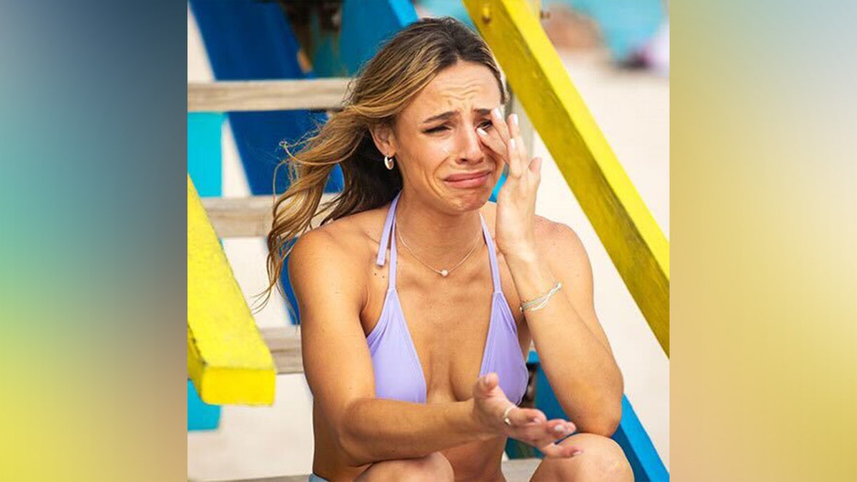 A girl in the age of college crying on the beach