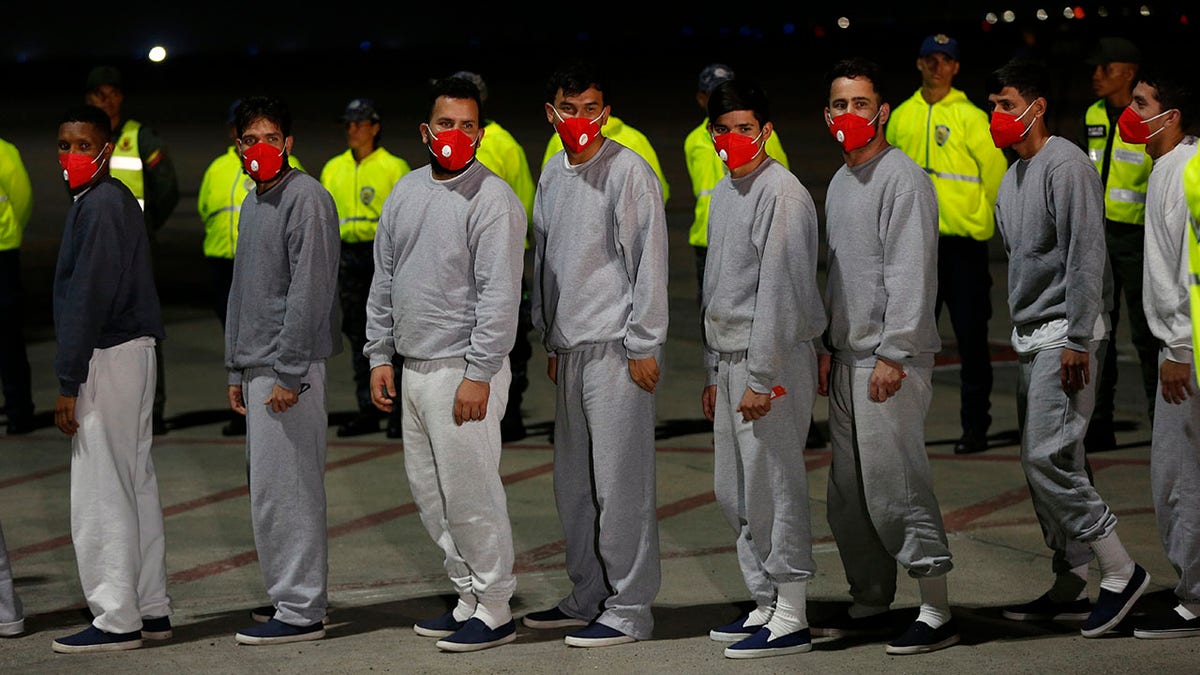 Migrants lined up to board a flight back home