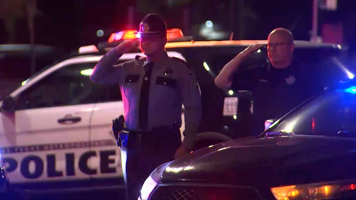 North Las Vegas Police Department (NLVPD) officers salute arsenic  different   officers thrust   past   connected  motorcycles successful  procession for a slain officer.