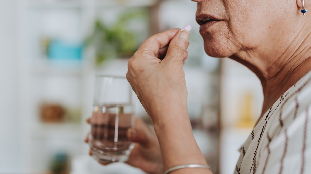 Old woman taking medicine